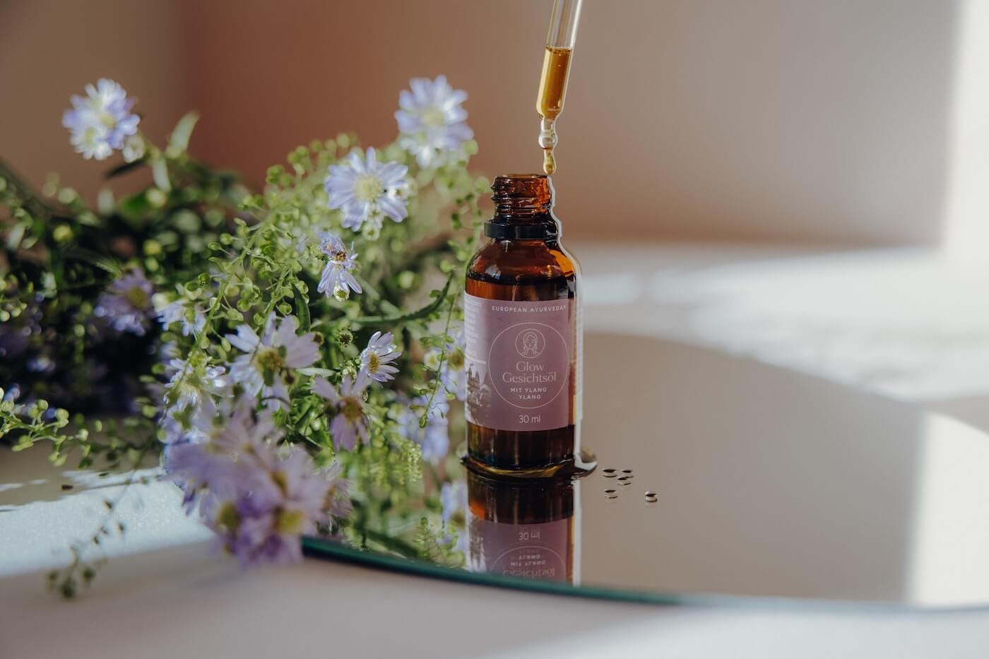 Gesichtsöl wird mit Pipette aufgetragen – Darstellung natürlicher Ayurveda Hautpflege für strahlende Haut.