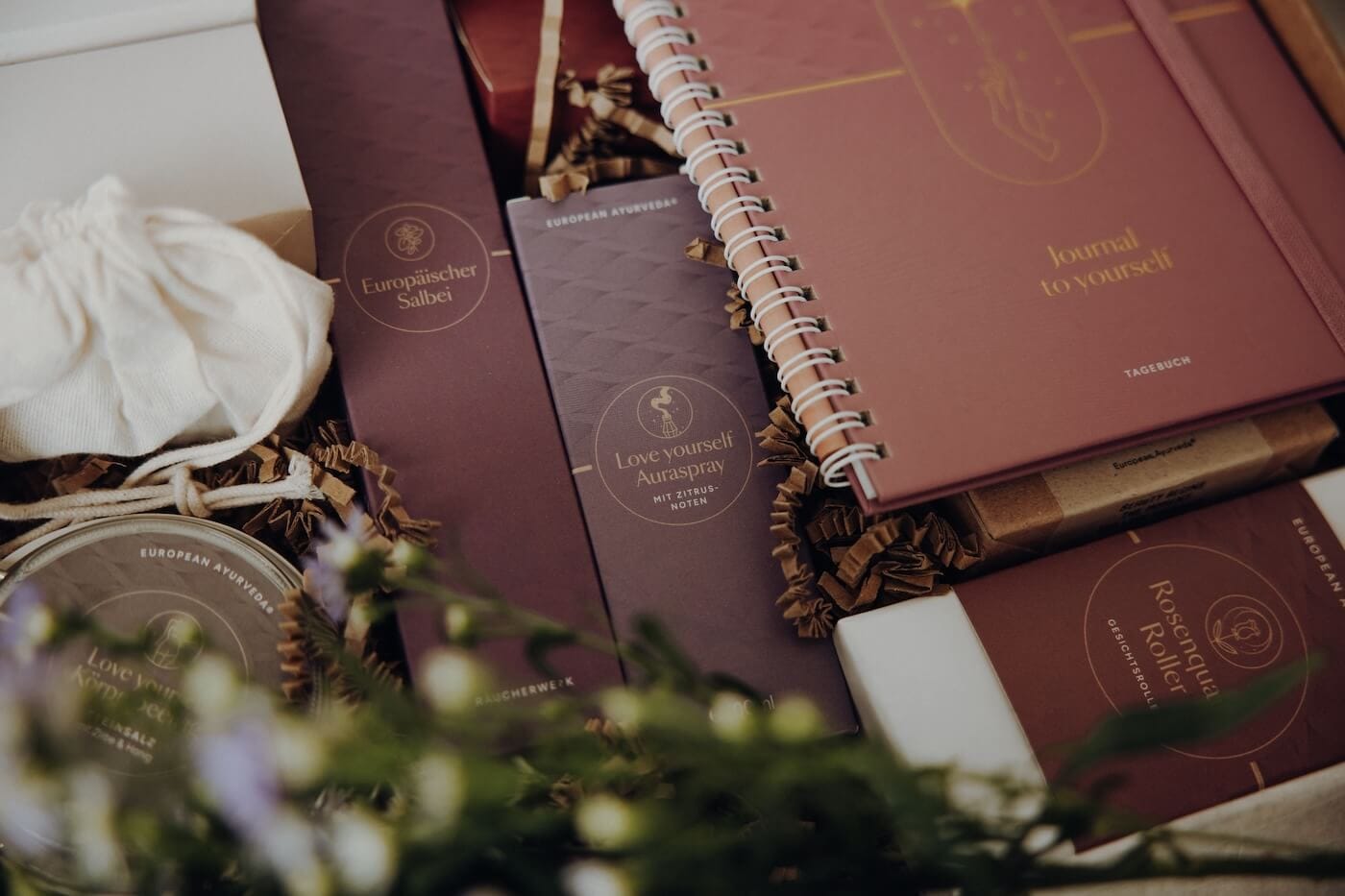 Ausgewählte Ayurveda Produkte wie Journals, Räucherwerk und Pflegeprodukte in einer Box – Darstellung eines ganzheitlichen Inner Beauty Rituals.
