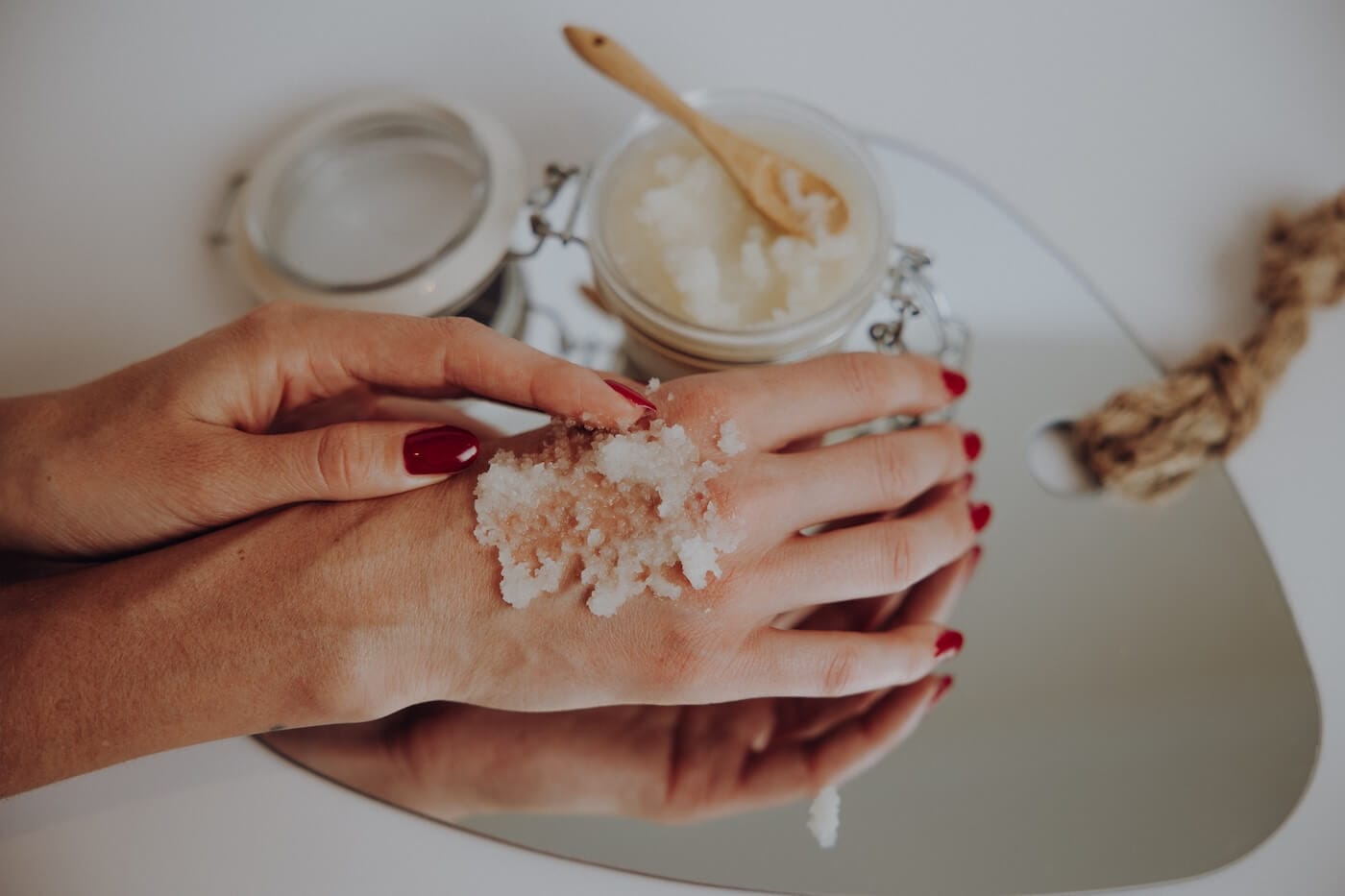 Hand trägt natürliches Körperpeeling auf – Darstellung von ayurvedischer Hautpflege und sanfter Reinigung.