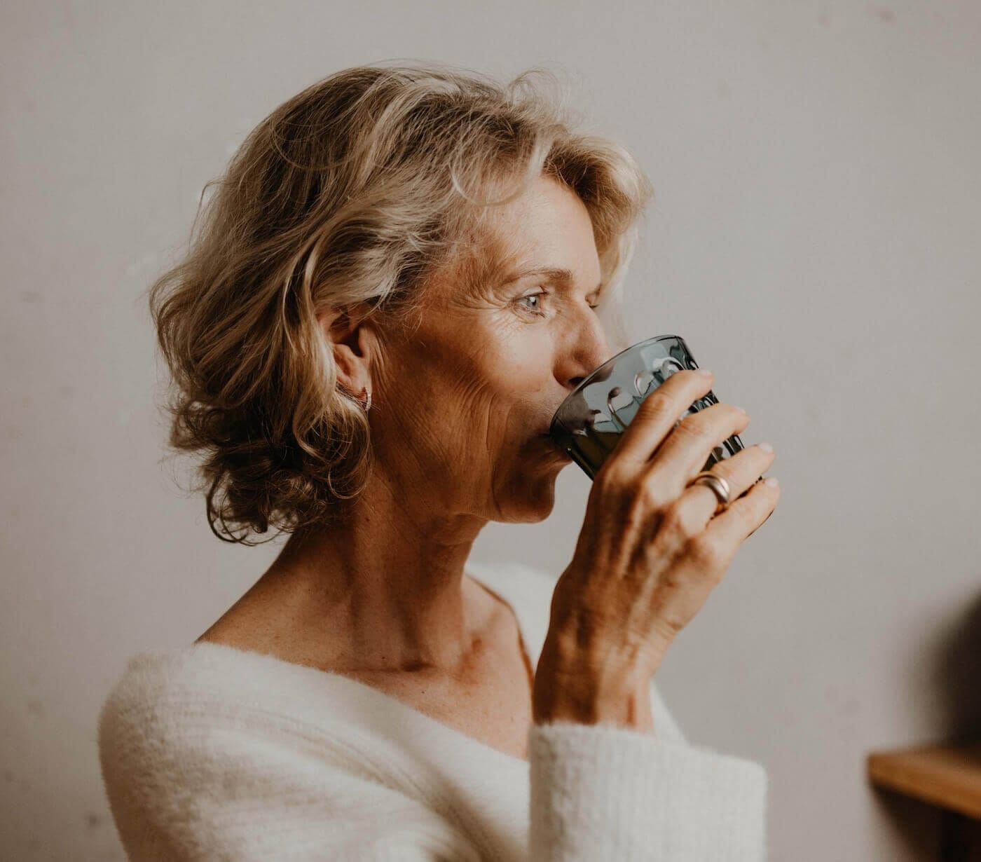Frau trinkt entspannt aus einer Tasse – Darstellung von regenerierenden Ayurveda Ritualen für Vitalität, Langlebigkeit und gesundes Altern.