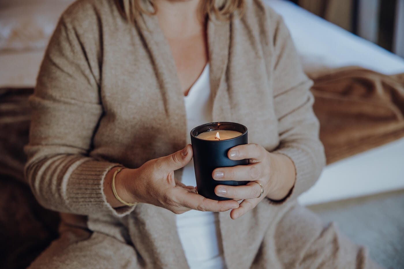 Person hält eine Kerze und entspannt sich – Symbol für Ayurveda Rituale zur Aktivierung und Balance des Kapha Doshas.