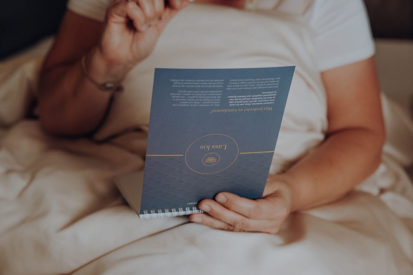 Person liest ein Ayurveda Buch entspannt auf dem Sofa – Symbol für Wissen, Achtsamkeit und persönliche Weiterentwicklung.
