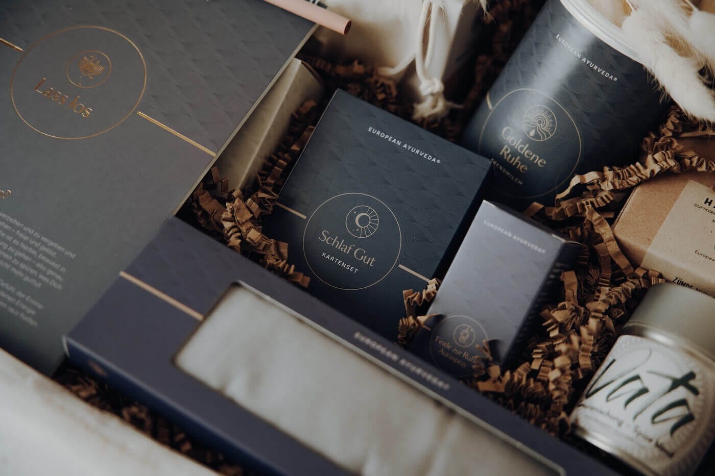 Ausgewählte Ayurveda Produkte wie Tees, Rituale und Entspannungsprodukte in einer Box – Darstellung eines ganzheitlichen Schlafprogramms.