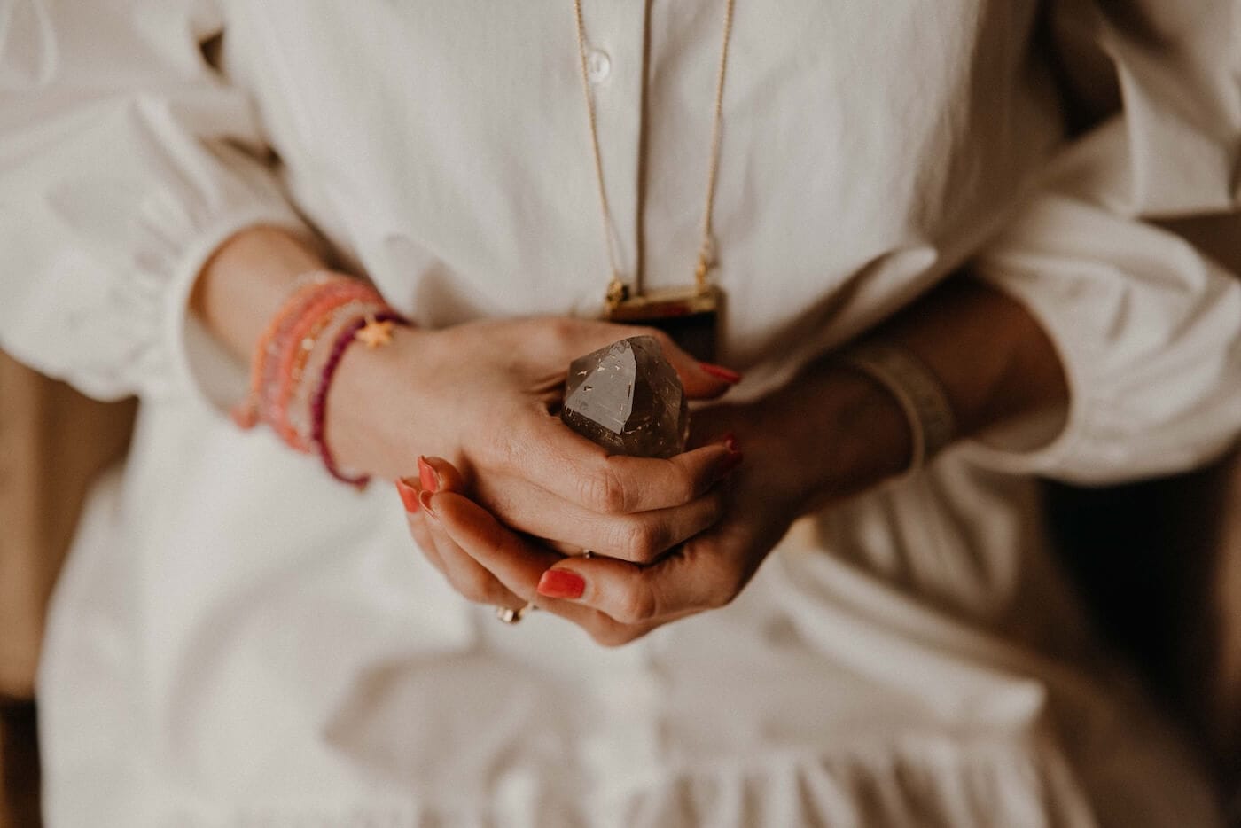 Frau hält einen Edelstein in den Händen – Symbol für weibliche Balance, innere Ruhe und hormonelles Gleichgewicht im Ayurveda.