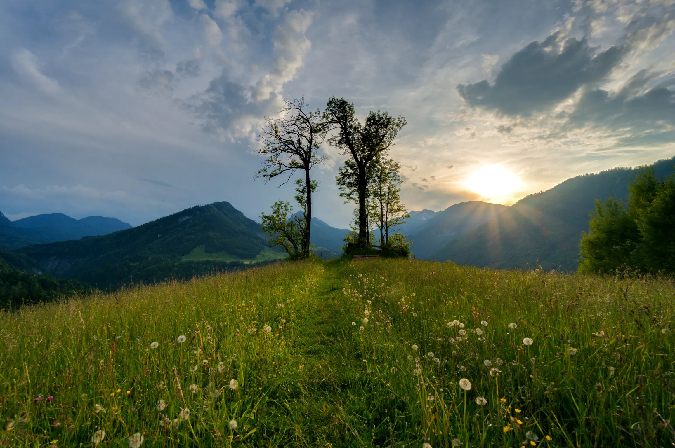 Bedecktes Himmel mit Sonnenschein mit Bergaussicht