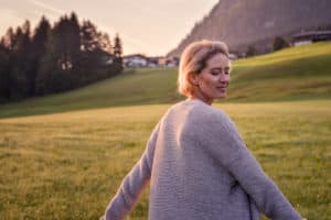 Frau steht auf einer Wiese